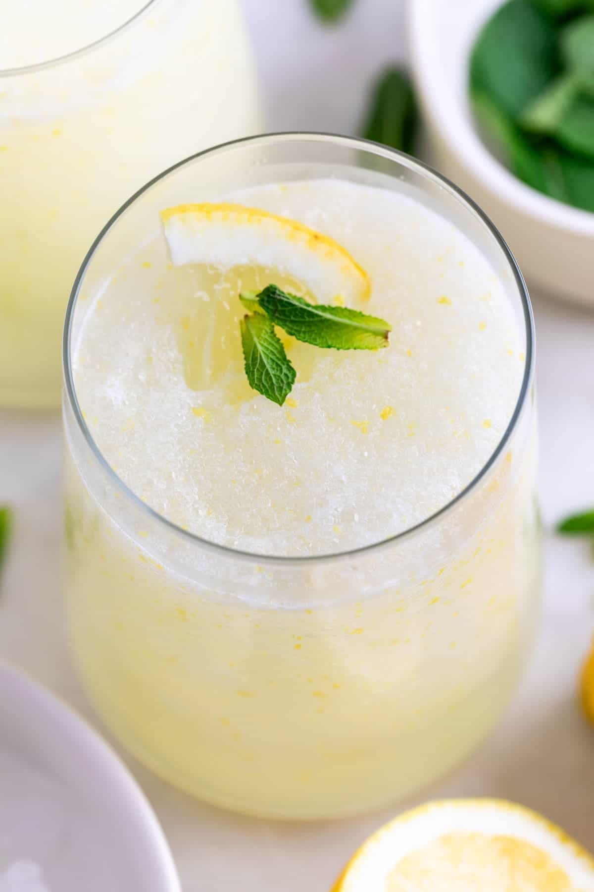 Granizado de lim&oacute;n casero en vasos con hojas de menta y rodaja de lim&oacute;n