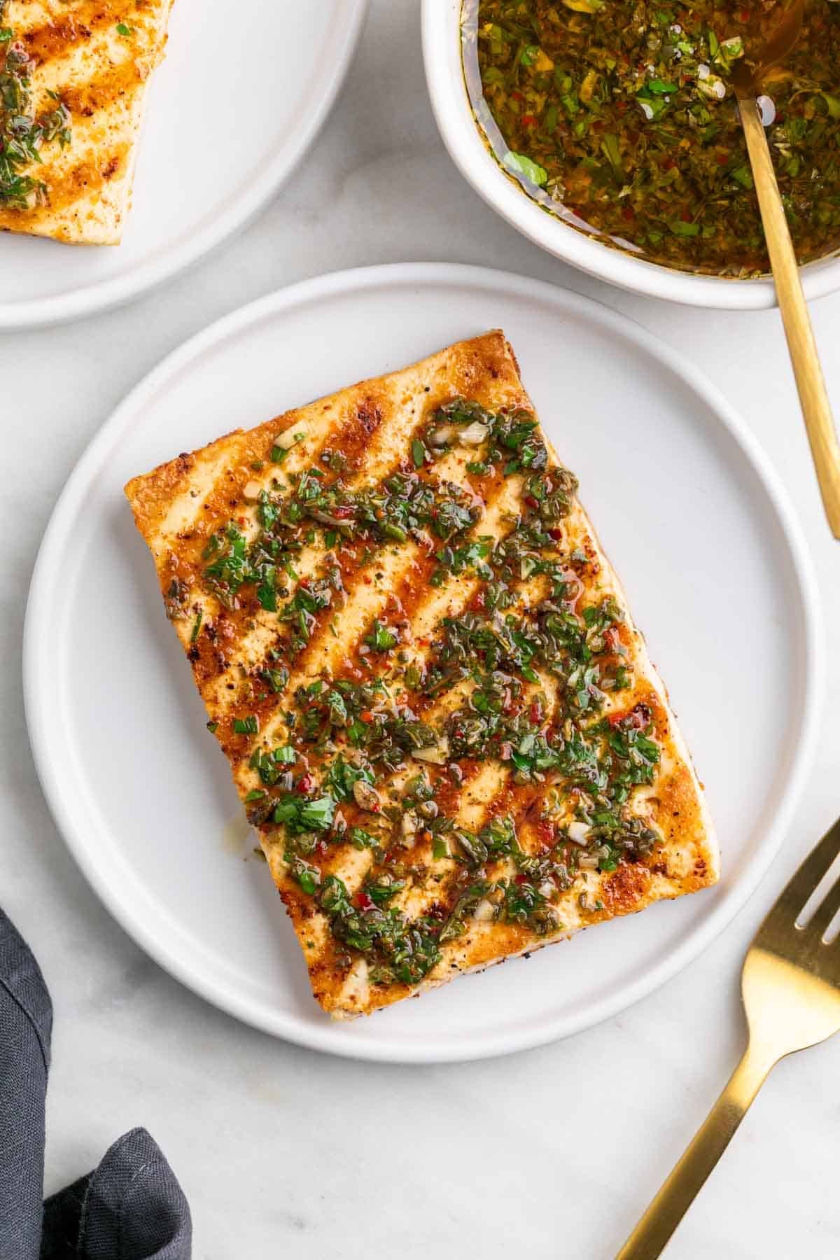 Filete de tofu a la plancha con chimichurri en un plato