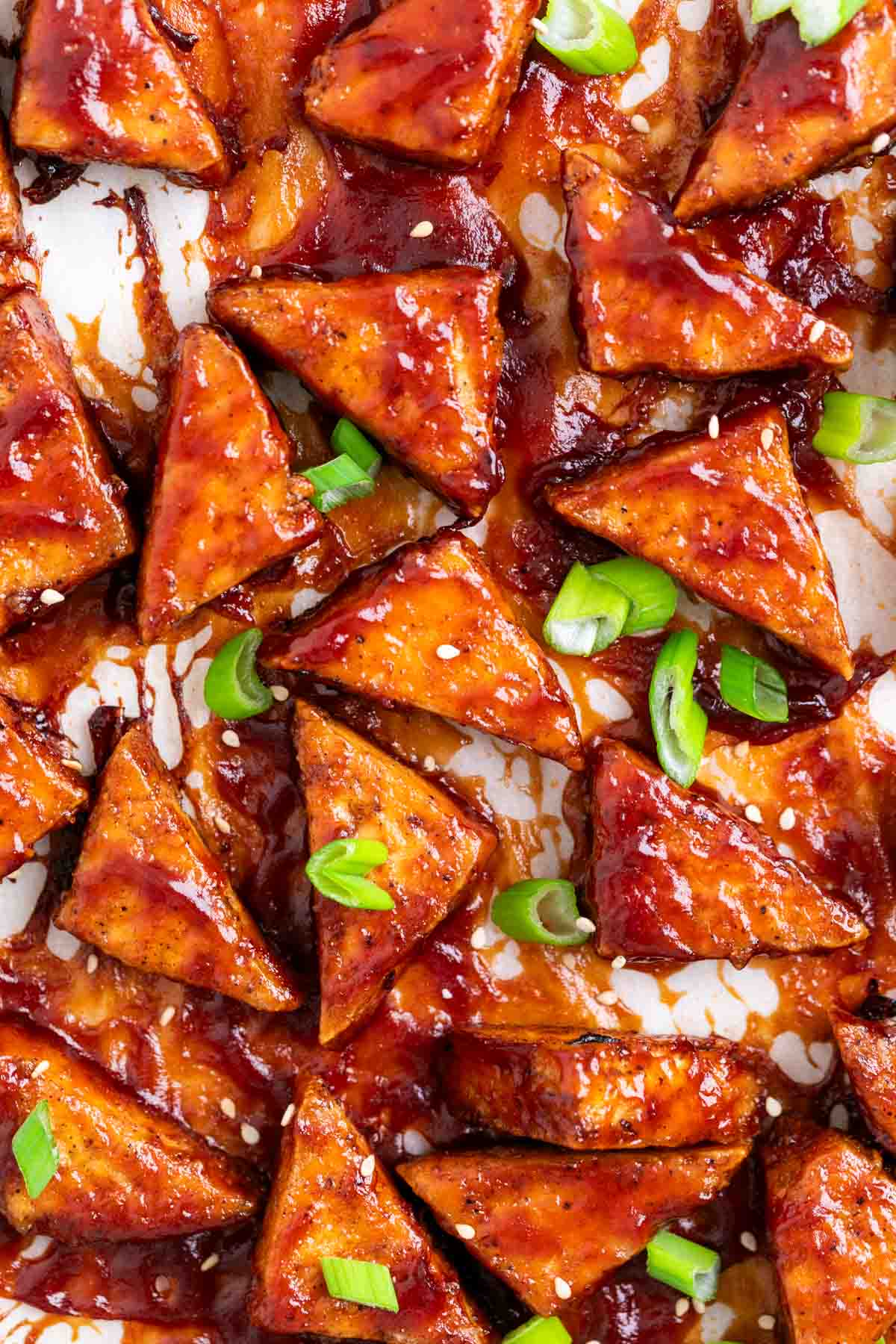 Tri&aacute;ngulos de tofu con salsa barbacoa horneados y decorados con cebolleta