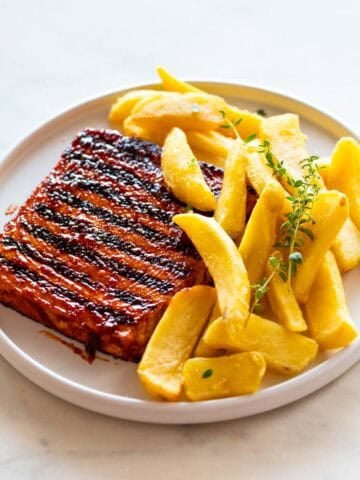 Dos filetes de tofu con marcas de grill servidos con patatas fritas