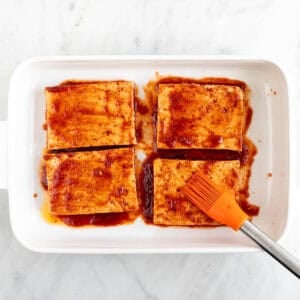 Brocha pintando los filetes de tofu con el marinado