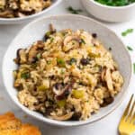 Arroz con setas servido en dos platos junto a un trozo de pan y perejil
