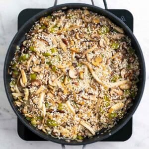 Arroz redondo mezclado con las verduras y las setas en la sartén