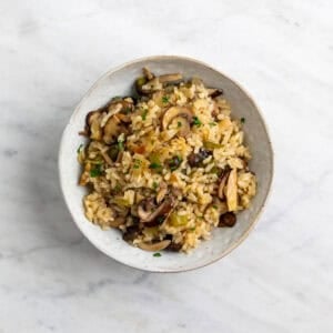 Arroz con setas en un plato con perejil fresco troceado por encima
