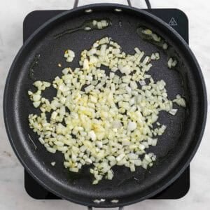 Cebolla cocinándose con aceite de oliva en una sartén