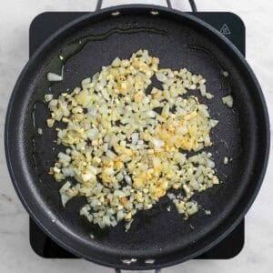 Cebolla y ajo cocinándose juntos en una sartén