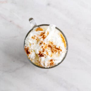 Pumpkin spice latte servido en una taza con nata montada y especias