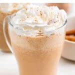 Dos tazas de pumpkin spice latte con café, calabaza y especias sobre la mesa