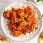 Dos boles de tofu tikka masala con arroz, perejil picado y pan naan